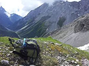 European Alpine Landscapes Prints: Backpack on mountain meadow with a view of steep