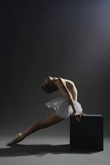 Dark Studio Photography Prints: A ballet dancer performs a graceful pose