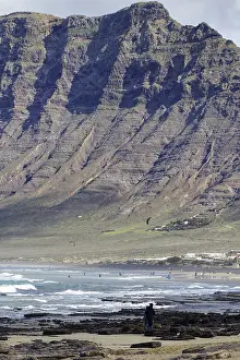 Mirador Risco De Famara Viewpoint Prints: Beach with rocks and cliffs (Risco de Famara) in the background