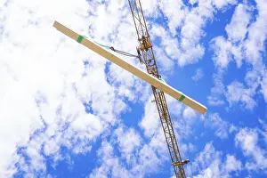 Overcast Sky With Clouds Prints: A beam is hoisted by a crane, sky and clouds in the background