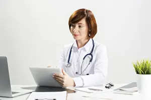 Medical Diagnosis Prints: Beautiful doctor using tablet computer in office