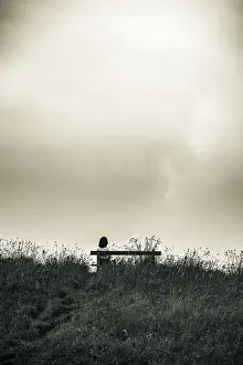 Dramatic Clouds Prints: Bench and mountaineer and dramatic clouds in the background