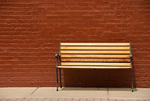 Brick Exterior Design Prints: A bench beside a red brick wall