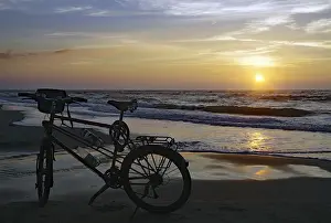 Evening Sun Denmark Prints: Bicycle on the beach in front of the setting sun