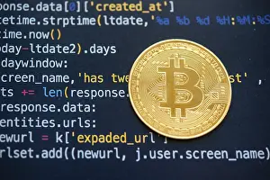 Blockchain Technology Symbol Prints: A Bitcoin coin on top of computer programming code