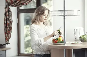 Woman Cooking Vegetables Prints: Blond lady at kitchen preparing vegetable for breakfast