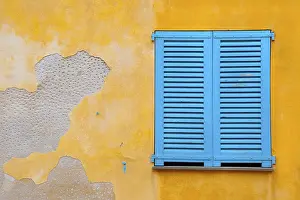 Deserted House Background Prints: Blue shutter on yellow plaster wall