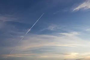 Beautiful Cloudy Skies Prints: Blue sunset sky with trace of the plane