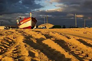 Cloudy Evening Sky Prints: Boat on the sand with clouds in sunset