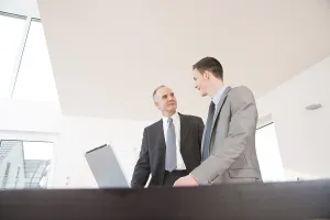 Businessman In Suit Prints: Boss and trainee working together on a computer