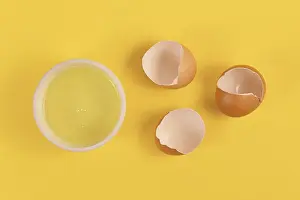 Broken Eggshells Prints: Bowl with egg white next to broken eggshells on yellow background