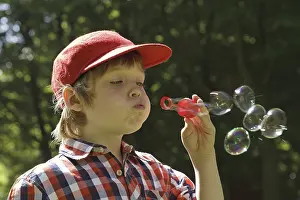 Casual Clothing Portrait Prints: Boy blowing soap bubbles