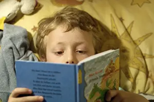Boy Reading In Bed Prints: Boy reading in bed