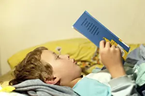 Boy Reading In Bed Prints: Boy reading in bed