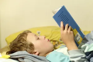 Boy Reading In Bed Prints: Boy reading in bed