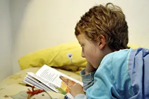 Boy Reading In Bed Prints: Boy reading in bed