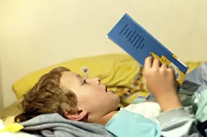 Boy Reading In Bed Prints: Boy reading in bed