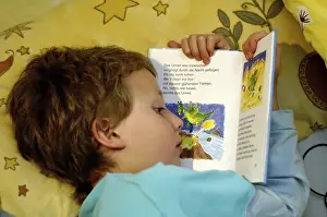 Boy Reading In Bed Prints: Boy reading in bed