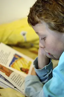 Boy Reading In Bed Prints: Boy reading in bed
