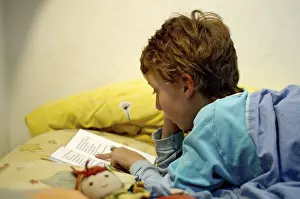 Boy Reading In Bed Prints: Boy reading in bed