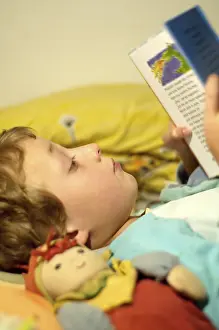 Boy Reading In Bed Prints: Boy reading in bed