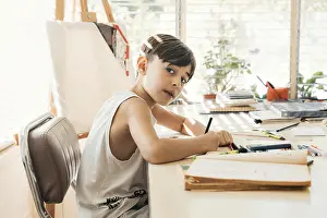 Boy Looking At Camera Prints: Boy sitting in his drawing class