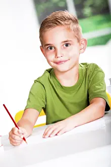 Boy Doing Homework Prints: Boy with a sketch-pad at a table