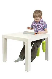 White Background Isolated Photo Prints: Boy with a Tablet PC on the desk in the studio on a white background