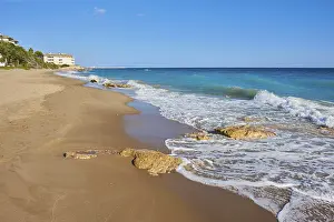 Steep Cliff Landscape Spain Prints: Breaking waves on a sandy beach with a rock