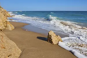 Spanish Rocky Coast Prints: Breaking waves on a sandy beach with a rock