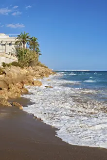 European Coastline Photography Prints: Breaking waves on a sandy beach with a view rocks