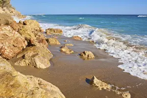 Tarragona Coastline Prints: Breaking waves on a sandy beach with a view rocks