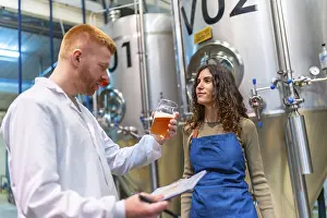 Industrial Building Architecture Prints: Brewery workers evaluating beer sample for quality control