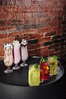 Elegant Table Setting Prints: Brightly colored beverages are elegantly arranged on a table against a rustic brick wall
