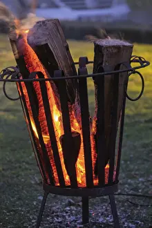 European Evening Sky Prints: Burning logs in a fire basket create a warm