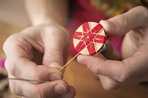 Handicraft Tool Prints: Button maker stitching and wrapping red and yellow yarn into star pattern