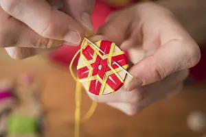 Handicraft Tool Prints: Button maker stitching and wrapping red and yellow yarn into star pattern
