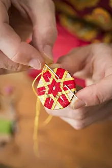 Regional Handicrafts Germany Prints: Button maker stitching and wrapping red and yellow yarn into star pattern