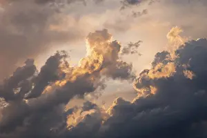 Sunset Atmosphere Prints: A captivating view of dramatic clouds illuminated by the warm glow of a sunset