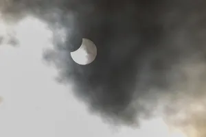 Solar Eclipse Prints: A partial solar eclipse occurs when the moon eclipses part of the sun and is surrounded by dynamic cloud formations