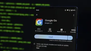 Digital Communication Tools Prints: Google Go app displayed on a smartphone screen with coding interface in the background