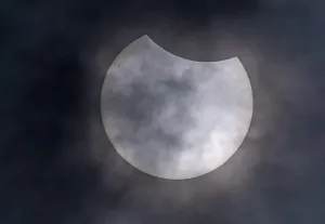 Natural Phenomena Europe Prints: Partial solar eclipse with clouds in the sky