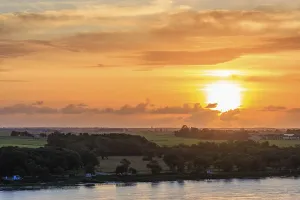 Dramatic Sunset Prints: Dramatic sunset over green fields and trees