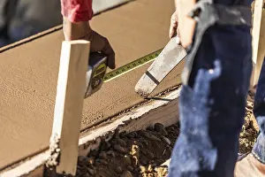 Real Estate Property Development Prints: Cement construction worker using measuring tape while forming pool coping