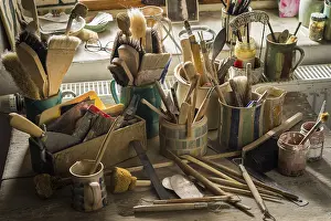 Ceramic Workshop Germany Prints: Ceramic workshop, tools and brushes in pots on workbench