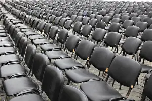 Empty Chair Rows Prints: Chairs covered with gray plastic stand in rows in a function room