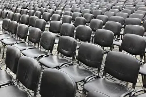 Empty Chair Rows Prints: Chairs covered with gray plastic stand in rows in a function room
