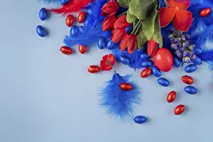 Ornate Easter Decorations Prints: Cheerful Easter decoration with a red egg surrounded by tulips and feathers