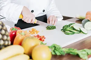 White Background Still Life Prints: Chef hands preparing and cutting vegetables