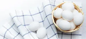 Fresh Chicken Eggs Prints: Chicken eggs on a checked kitchen towel on a light table